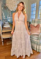 Woman in a white lace dress standing in a living room.