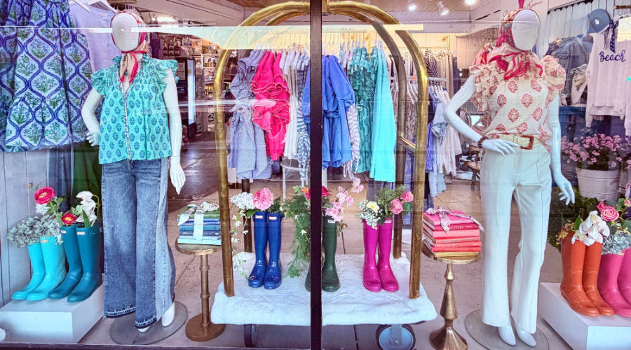 Display window of a store with mannequins, clothing, and accessories.